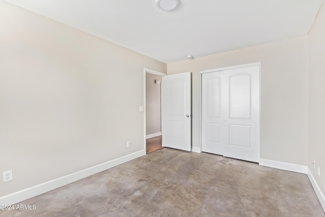 unfurnished bedroom featuring light colored carpet and a closet