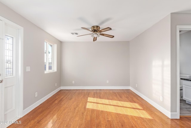 spare room with ceiling fan, a healthy amount of sunlight, and light hardwood / wood-style floors