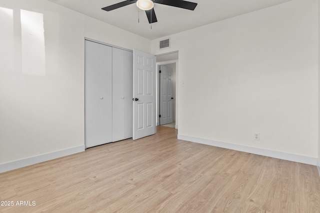 unfurnished bedroom with baseboards, visible vents, a closet, and light wood-type flooring