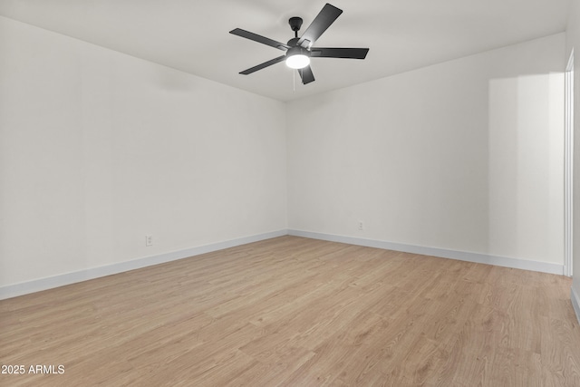 spare room featuring light wood-style floors, baseboards, and ceiling fan