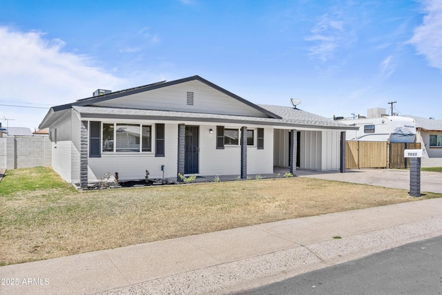 view of front of home featuring a front lawn, fence, and roof with shingles