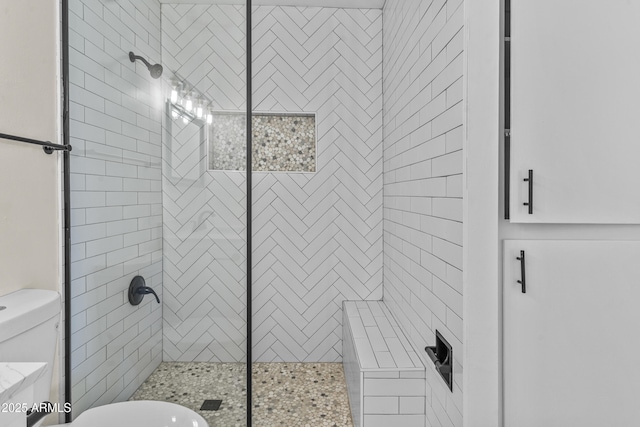 bathroom featuring toilet and a stall shower