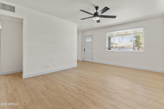 spare room featuring wood finished floors, visible vents, and baseboards