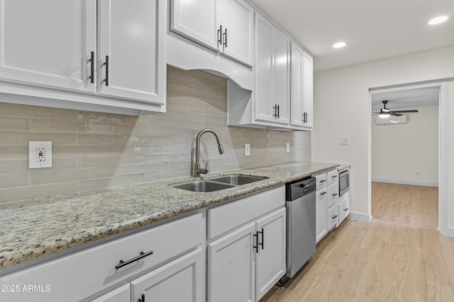 kitchen featuring a sink, backsplash, white cabinetry, stainless steel appliances, and ceiling fan