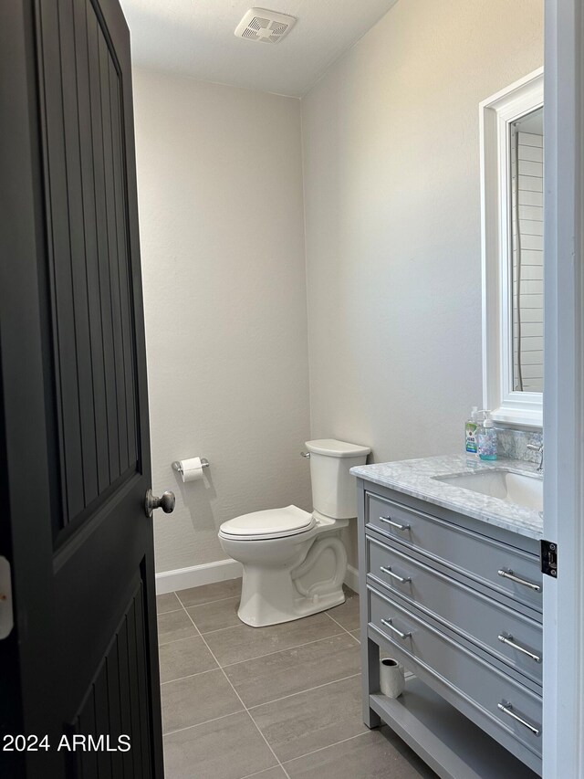 bathroom with tile patterned flooring, vanity, and toilet