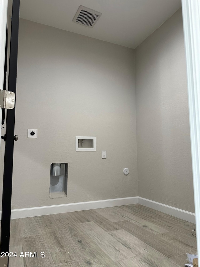 laundry area featuring washer hookup, hookup for a gas dryer, light hardwood / wood-style floors, and electric dryer hookup