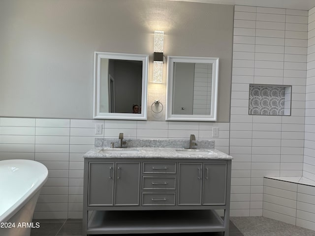 bathroom featuring a bathtub, vanity, tile walls, and tile patterned flooring