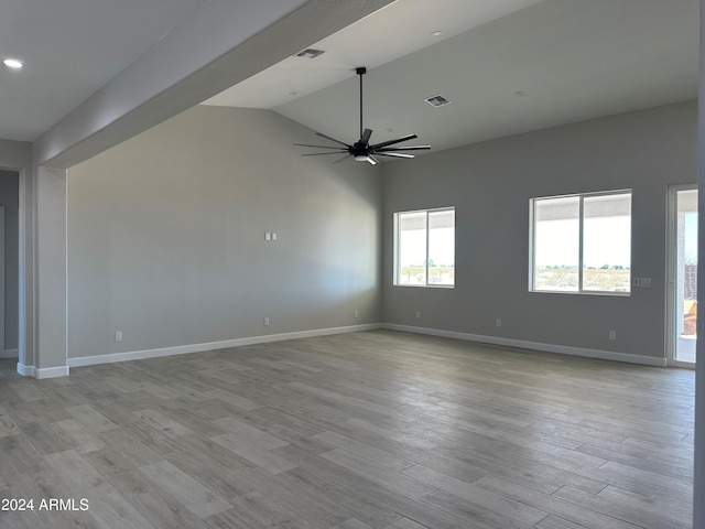 empty room featuring ceiling fan, lofted ceiling, and light wood-type flooring