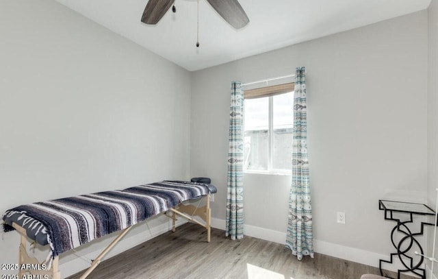 bedroom featuring a ceiling fan, baseboards, and wood finished floors