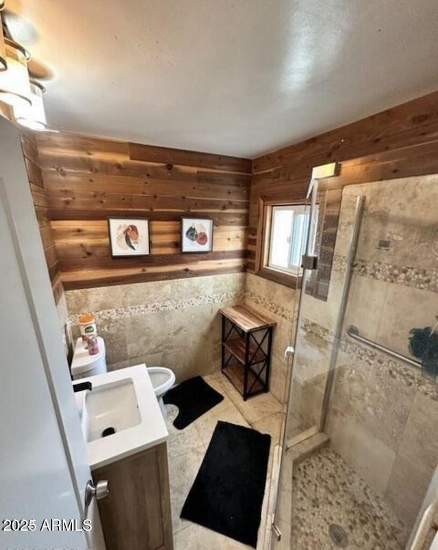 full bathroom featuring a stall shower, toilet, wood walls, and vanity