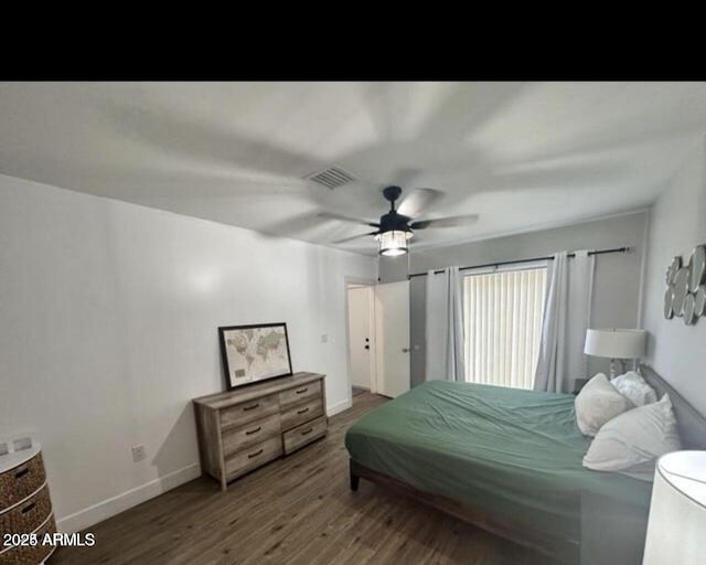 bedroom featuring baseboards, visible vents, ceiling fan, and wood finished floors