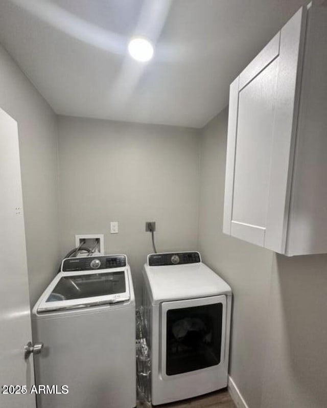 laundry area featuring baseboards, washer and dryer, and cabinet space