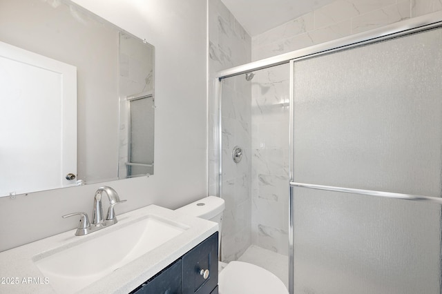 bathroom with toilet, vanity, and a shower stall