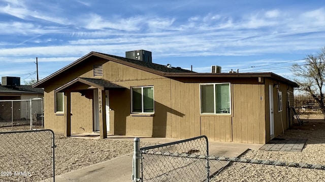 view of home's exterior featuring central air condition unit, a gate, and fence