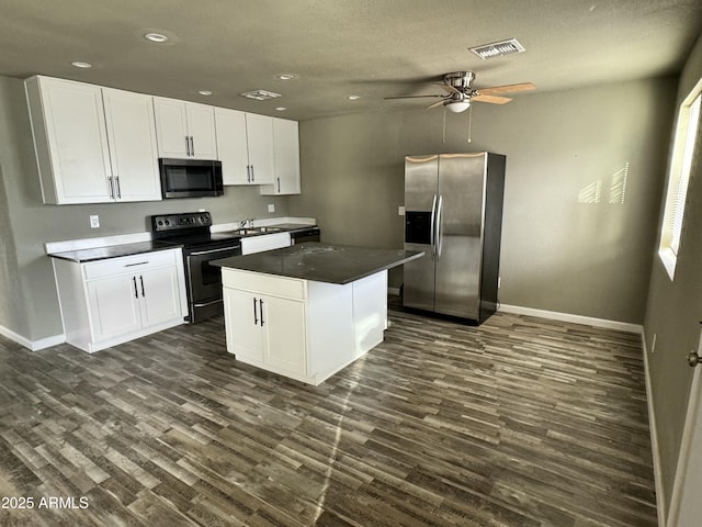 kitchen featuring electric range, visible vents, white cabinetry, stainless steel refrigerator with ice dispenser, and dark countertops