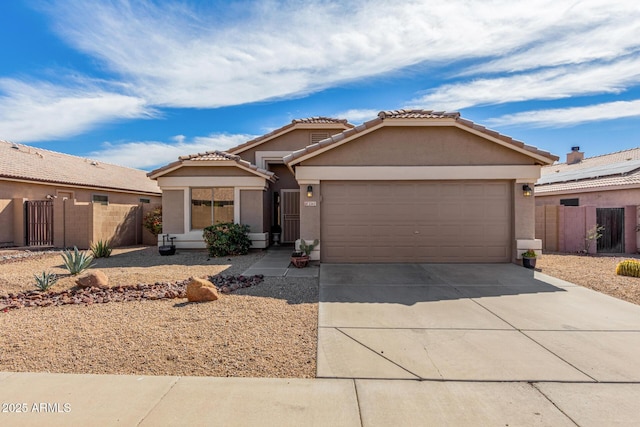 view of front of property featuring stucco siding, concrete driveway, an attached garage, fence, and a tiled roof