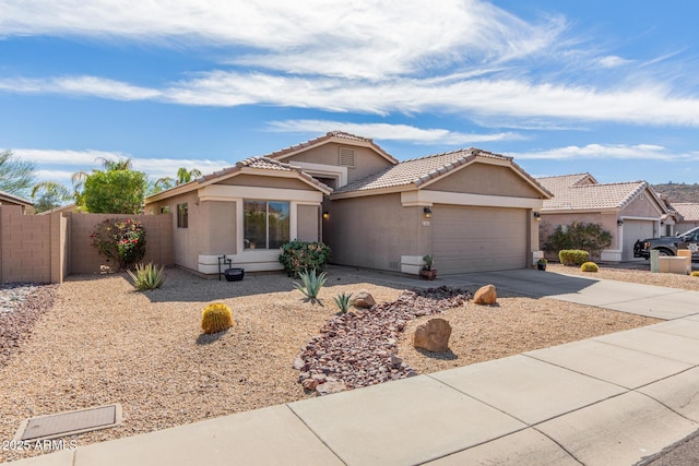 view of front of property featuring concrete driveway, a tiled roof, an attached garage, fence, and stucco siding