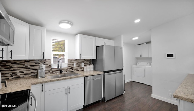 kitchen featuring sink, white cabinets, washer and dryer, and stainless steel dishwasher