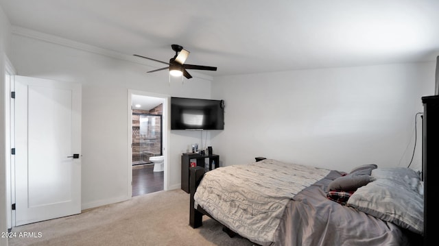 bedroom featuring connected bathroom, ceiling fan, and light colored carpet