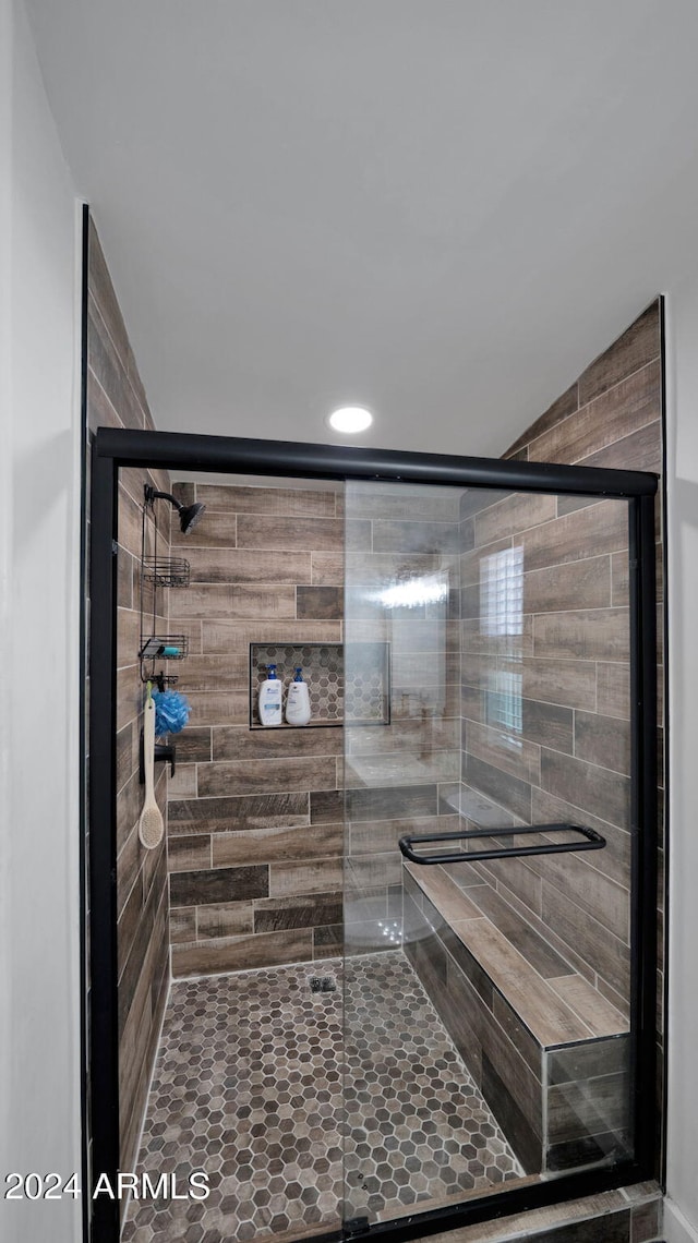 bathroom with a shower with door