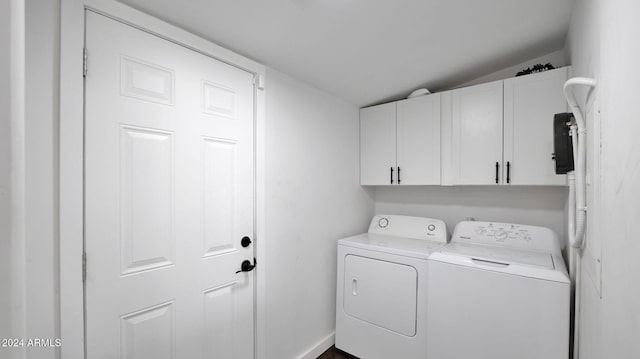 laundry room featuring washer and clothes dryer and cabinets