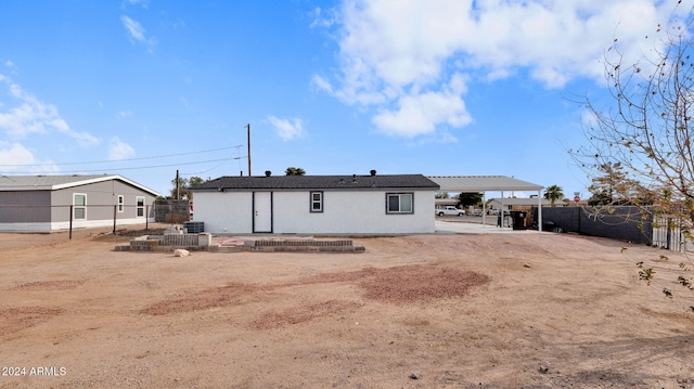 back of house with a carport and central AC