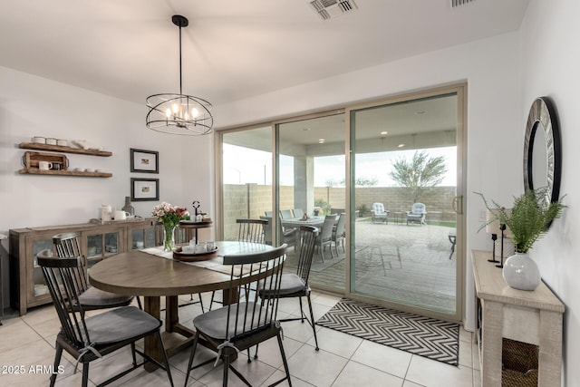 dining area with light tile patterned floors, visible vents, and an inviting chandelier