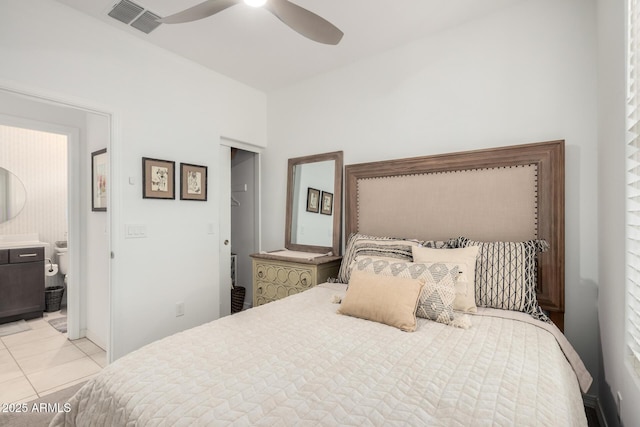 bedroom featuring light tile patterned floors, ensuite bath, visible vents, and a ceiling fan