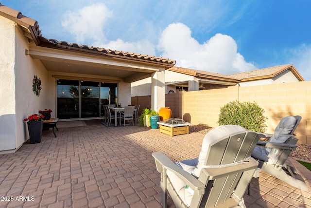 view of patio / terrace with an outdoor fire pit, fence, and outdoor dining space