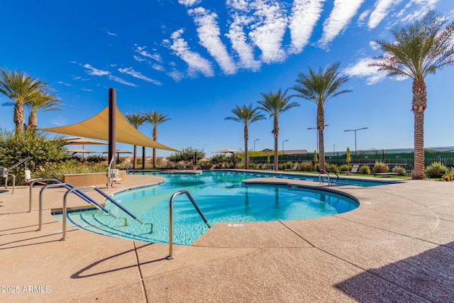 pool with a patio and fence