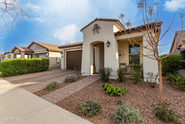 mediterranean / spanish home with a garage, a tile roof, driveway, and stucco siding