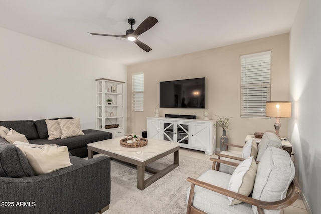 living room with light tile patterned floors, baseboards, and a ceiling fan