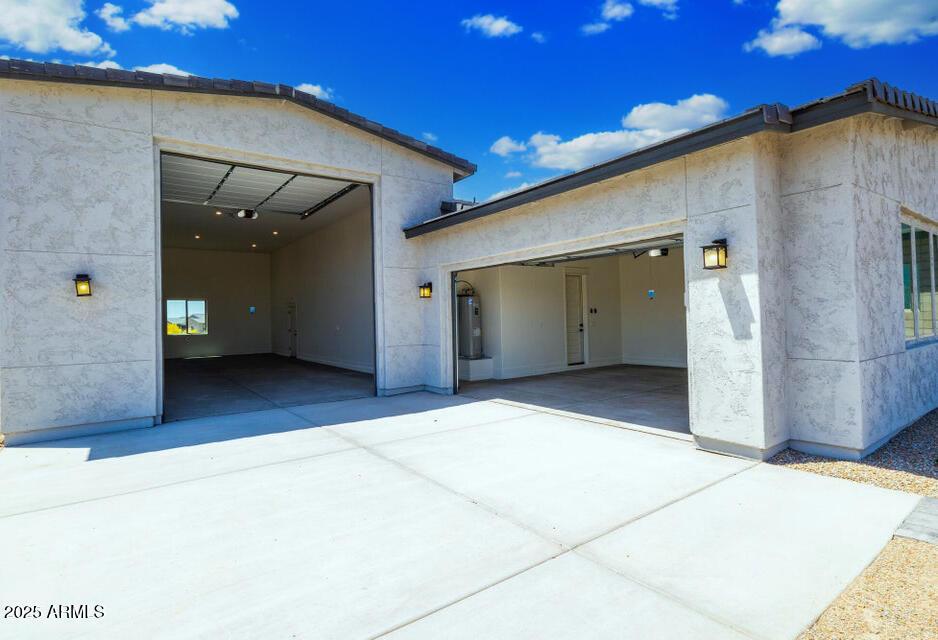 exterior space featuring a garage and electric water heater