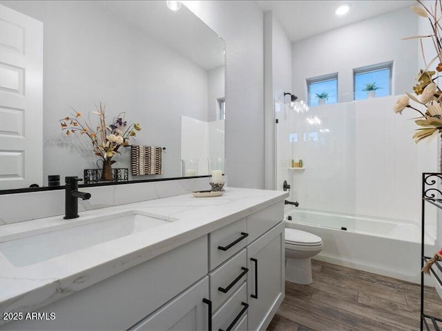 full bathroom featuring shower / bathing tub combination, vanity, wood-type flooring, and toilet