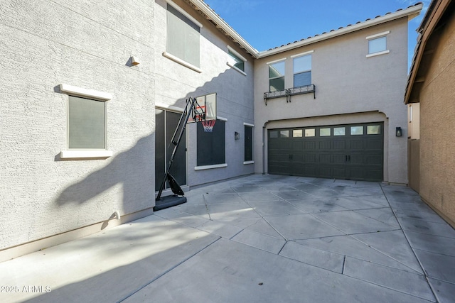 view of home's exterior featuring an attached garage, driveway, and stucco siding