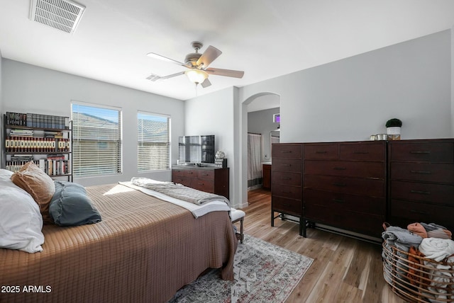 18841 E Pelican Ct, Queen Creek, AZ 85142 - bedroom with arched walkways, visible vents, light wood finished floors, and a ceiling fan