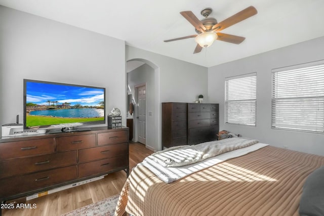 18841 E Pelican Ct, Queen Creek, AZ 85142 - bedroom with arched walkways, ceiling fan, and light wood-style floors
