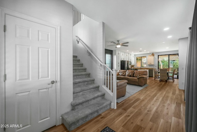 stairway featuring recessed lighting, ceiling fan, and wood finished floors