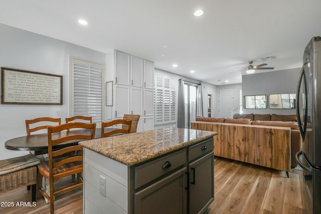 18841 E Pelican Ct, Queen Creek, AZ 85142 - kitchen with recessed lighting, light wood-type flooring, freestanding refrigerator, and a kitchen island