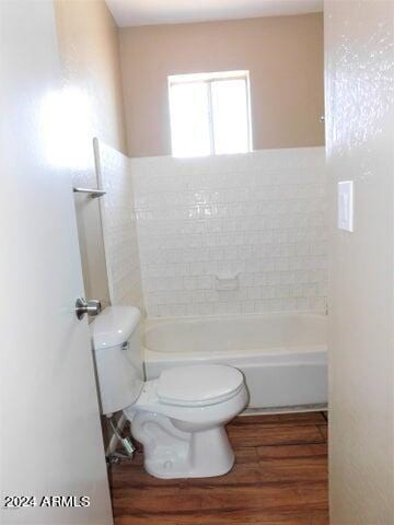 bathroom featuring toilet, bathtub / shower combination, and wood-type flooring