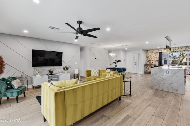 living area featuring recessed lighting, light wood-type flooring, visible vents, and a ceiling fan