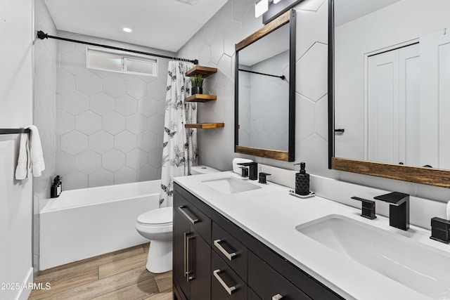 full bath featuring shower / bath combination with curtain, wood finished floors, a sink, and toilet