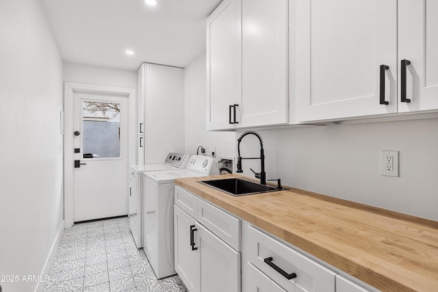 laundry area featuring a sink, washing machine and dryer, recessed lighting, cabinet space, and light tile patterned floors