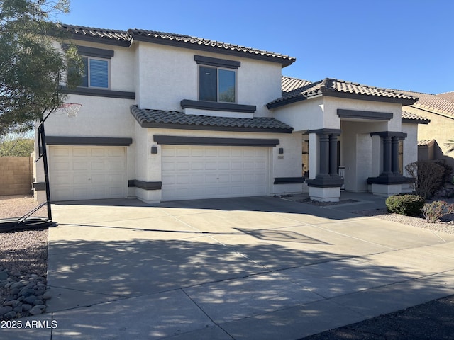 mediterranean / spanish house featuring a garage, driveway, and stucco siding