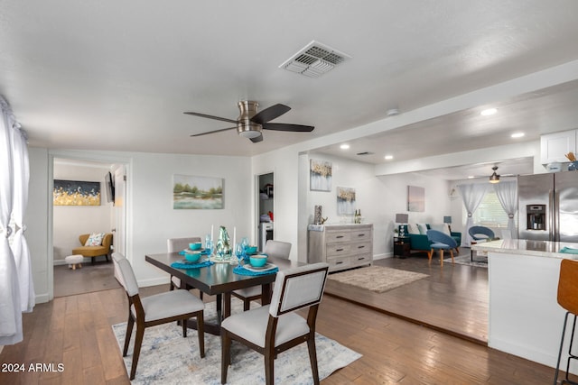 dining area with dark wood-type flooring and ceiling fan