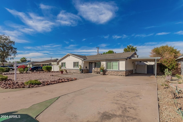 2518 E Campbell Ave, Phoenix, AZ 85016 - ranch-style house with stone siding, stucco siding, a carport, concrete driveway, and fence