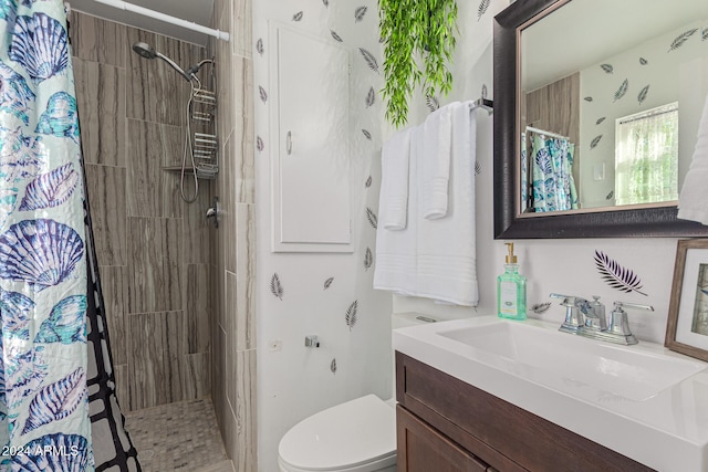 bathroom with walk in shower, vanity, and toilet