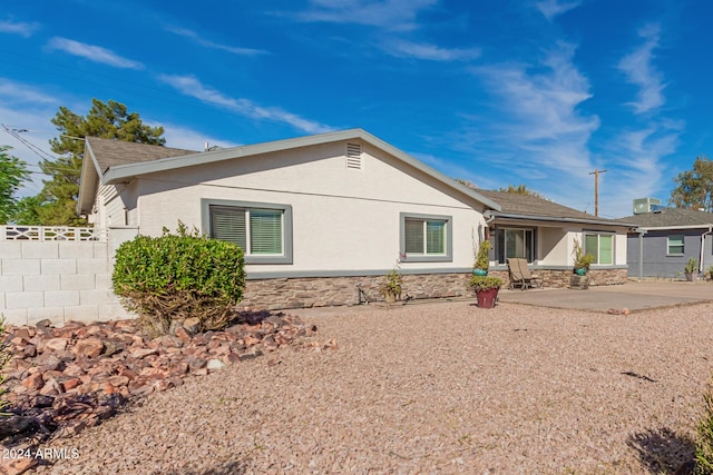 2518 E Campbell Ave, Phoenix, AZ 85016 - rear view of house featuring fence, stone siding, stucco siding, and a patio