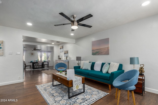 living room with dark wood-type flooring and ceiling fan