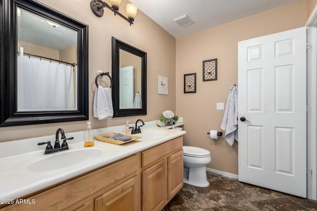 4038 E Wrangler Ct, Gilbert, AZ 85297 - bathroom featuring toilet, double vanity, baseboards, and a textured ceiling